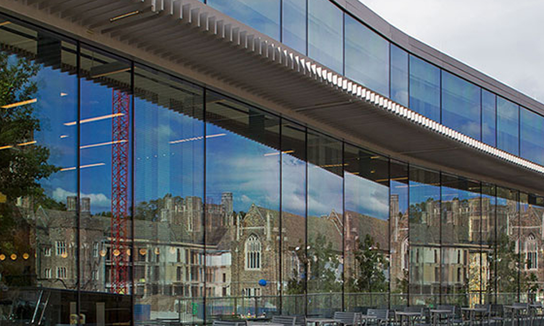 Modern glass conference venue at Duke University reflecting historic campus architecture