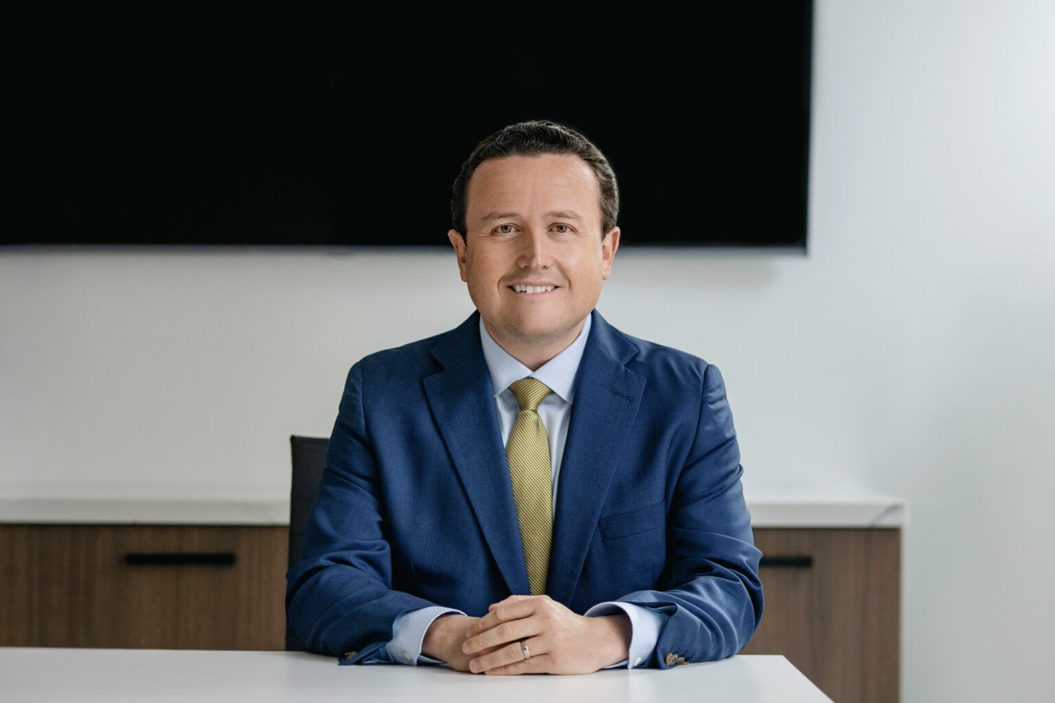 Professional portrait of Daniel Spuller in a blue suit
